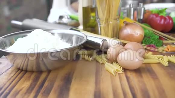 碗中的食物组成面粉鸡蛋和蔬菜用于在木桌上的披萨上烹饪意大利面食物成分视频的预览图