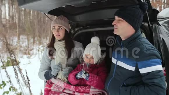 幸福的家庭喝茶享受冬天的风景家庭假日在冬林视频的预览图