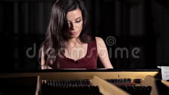 一个年轻女孩弹钢琴音乐会前排练古典音乐视频的预览图