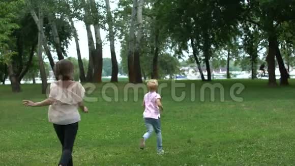 妈妈和儿子在公园玩追赶游戏一起欣赏时光快乐童年视频的预览图