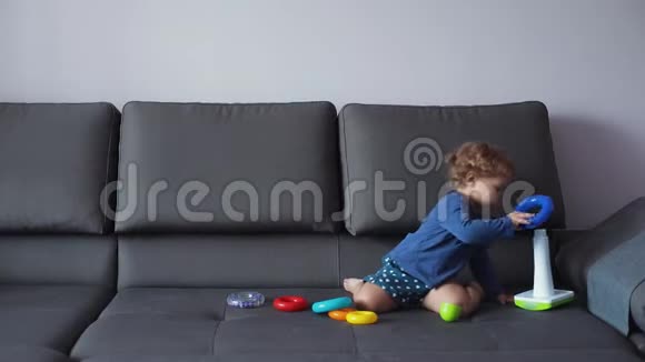 金发卷发的小女孩玩教育玩具蓝色的衣服感觉很开心视频的预览图