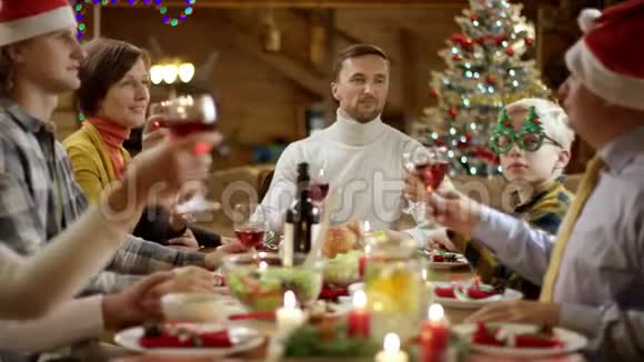 一家人在圣诞餐桌旁碰杯葡萄酒视频的预览图