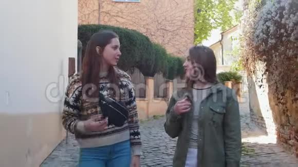 两个年轻的女人走在狭窄的街道上聊天视频的预览图