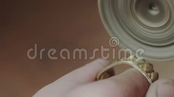 男金匠手正在抛光一个金冠环用专业的抛光工具手工制作或手工制作视频的预览图
