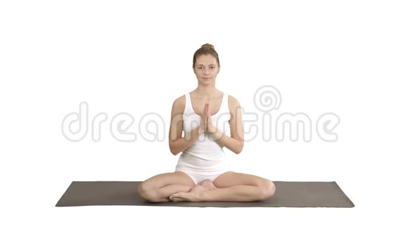 美丽的女人在莲花中练习瑜伽姿势伸展手在头上靠在一边另一边在白色上视频的预览图