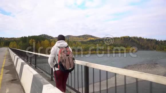 旅行者的女人沿着桥穿过山河堕落视频的预览图