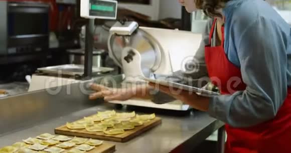 4k面包店使用数码平板电脑的女性面包师视频的预览图