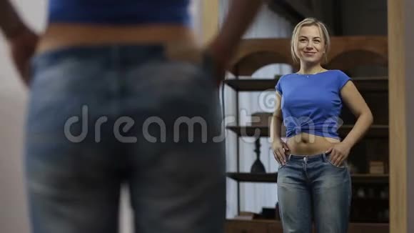 减肥后穿旧牛仔裤的兴奋女人视频的预览图