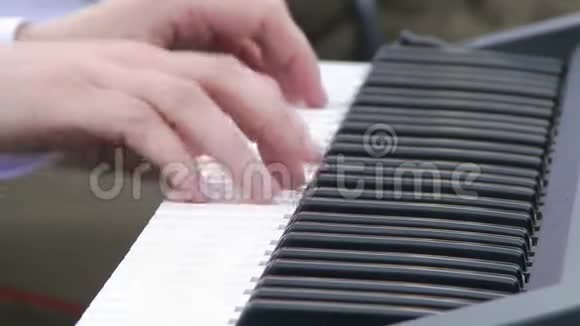 年轻的女人学会弹数字钢琴那个女孩有一件白色衬衫白色钢琴视频的预览图