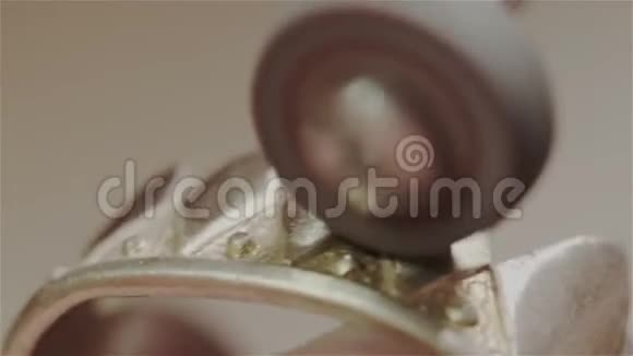 男性珠宝商或金匠在珠宝制作车间抛光和抛光金戒指的形状皇冠旋转视频的预览图