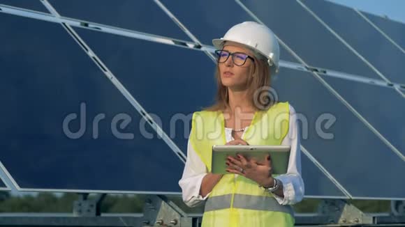 女性能量学专家正在太阳能阵列附近工作微笑着视频的预览图