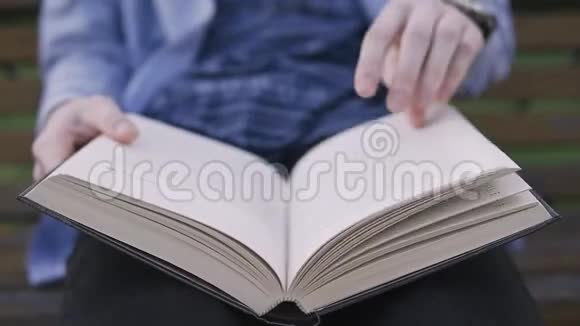 一个人在近距离阅读一本书时翻了一页视频的预览图