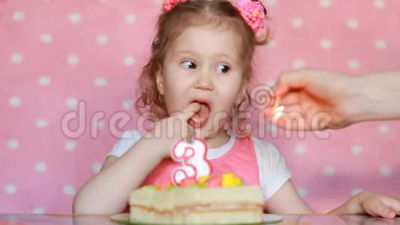 一个可爱的小女孩许愿在聚会上吹灭生日蛋糕上的蜡烛可爱的孩子儿童的概念视频的预览图