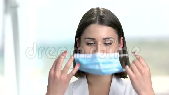 关闭女医生戴上口罩视频的预览图