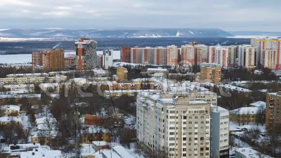 冬季寒冷的河流和山脉附近的城市中的小而高的住宅视频的预览图