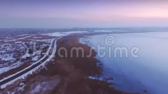 郊区道路和冰冻湖泊的空中时间推移视频的预览图