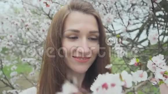 春天盛开的大树旁美丽的姑娘视频的预览图