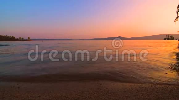 在美丽的夕阳下海浪在沙滩上缓缓拍打视频的预览图