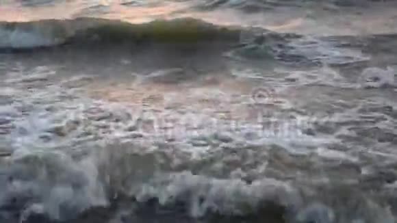 日落时海浪拍打着沙滩视频的预览图