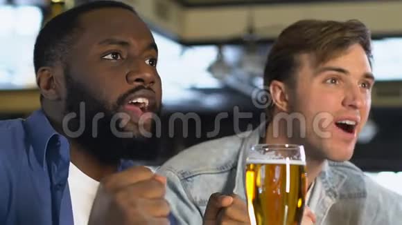快乐的男性朋友碰啤酒杯在酒吧看比赛庆祝视频的预览图