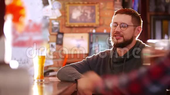 坐在酒吧里的胡子男他的朋友坐在他旁边他们握手视频的预览图