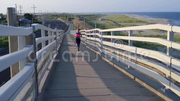 日落时分年轻女子在海滩上跑步耐力锻炼视频的预览图