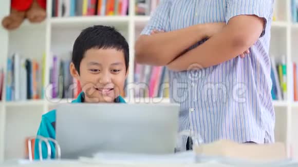 Preteen男孩用笔记本电脑和老师学习视频的预览图