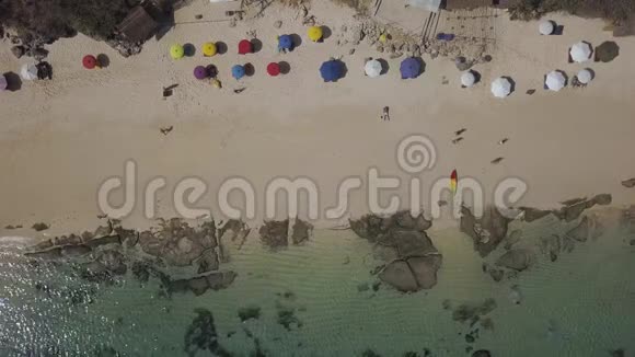 空中人和五颜六色的雨伞在海滩上视频的预览图