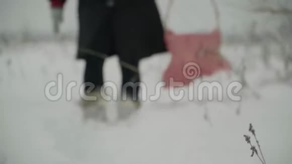 那个女孩带着篮子走在冬天的小路上穿过暴风雪视频的预览图