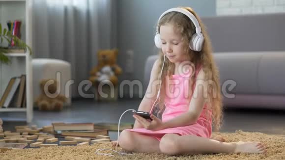 小孩用小工具听最喜欢的音乐用耳机唱歌视频的预览图