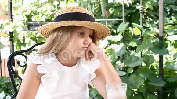 戴草帽在花园里享受阳光的可爱女孩的肖像假装女孩在镜头前微笑和清洗4k视频的预览图