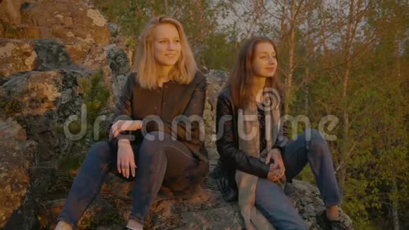 两个女孩坐在石头上视频的预览图