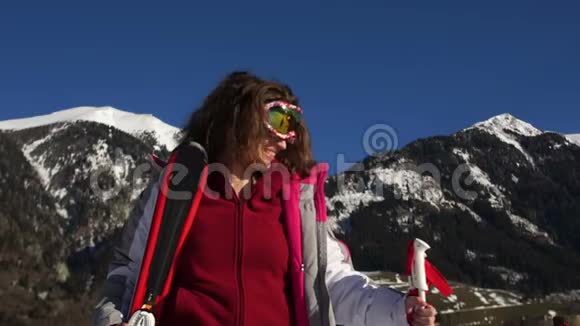年轻活跃的女人在山上滑雪瑞士女滑雪者戴着安全护目镜和杆享受阳光明媚的冬日视频的预览图