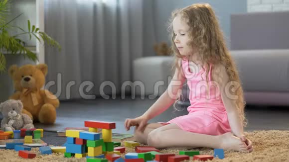 小女孩在家里搭建玩具塔玩有机木积木视频的预览图