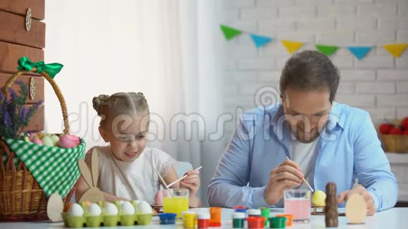 复活节快乐的女儿和父亲玩着用画笔互相绘画视频的预览图