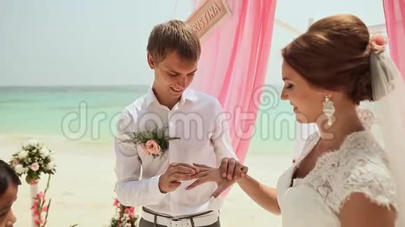 新娘和新郎互相戴戒指在菲律宾海滩举行婚礼视频的预览图