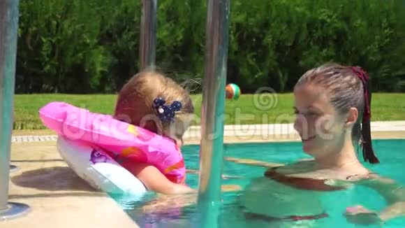女人和小女孩在游泳池里玩视频的预览图