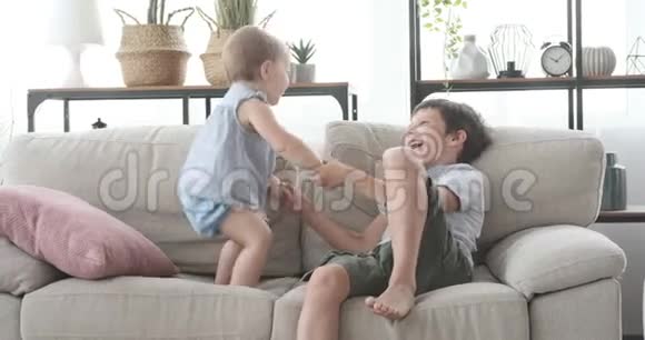 孩子在沙发上和妹妹玩视频的预览图