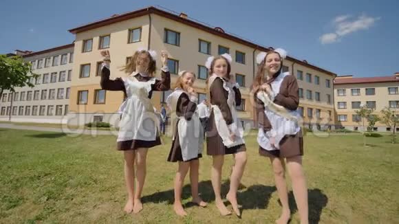 穿着校服毕业的女孩给相机送上一个空中吻俄罗斯毕业生庆祝最后一个学年视频的预览图