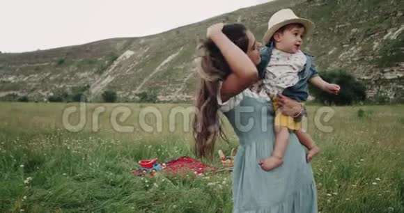 有魅力的小男孩和他的妈妈在山上玩在一起微笑着4k视频的预览图