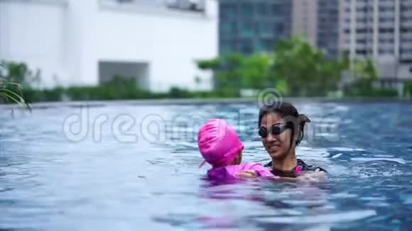妈妈教小女孩在游泳池游泳视频的预览图