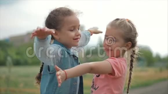 两个微笑卷曲可爱的姐妹紧紧地拥抱着对方快乐童年积极情绪真情实感视频的预览图