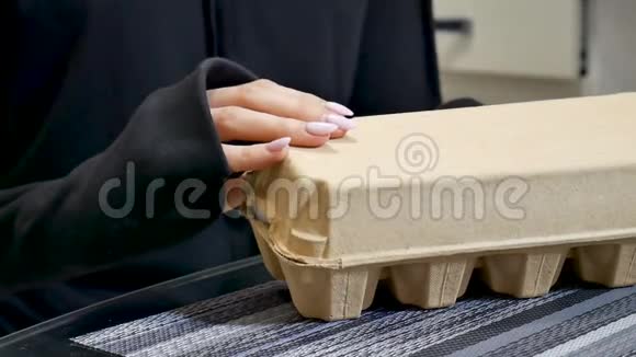 合拢的雌性手打开一个纸板蛋盒里面有白鸡蛋环境包装概念视频的预览图