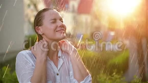 美丽的女人湿发享受雨仰望天空夏日花园里的美女有很多视频的预览图