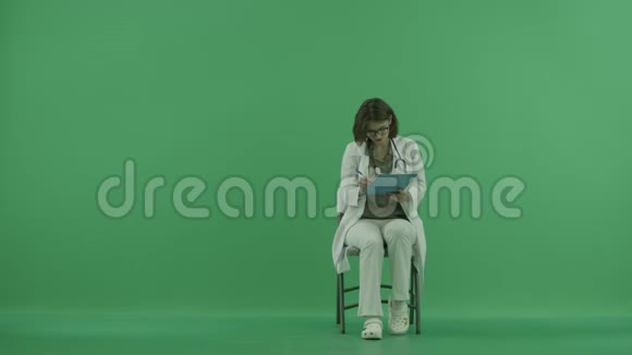 医生在绿色屏幕上完成书写并佩戴听诊器视频的预览图