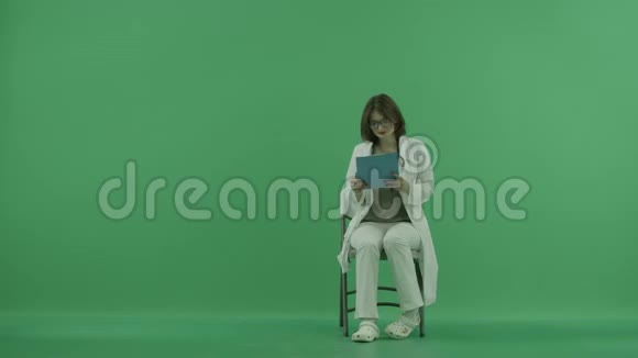医生坐在椅子上进行检查在绿色屏幕上记录视频的预览图