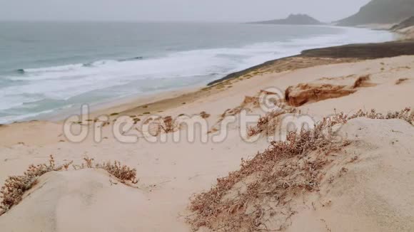 白色的沙丘和火山岩海浪慢慢地拍打着海滩卡尔豪圣维森特岛角视频的预览图
