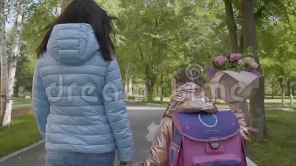暑假过后一年级的女孩和妈妈一起散步视频的预览图