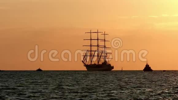 一个夏天的早晨日出时分在靠近海岸的地方有一艘三桅船海港的剪影旅游船漂浮视频的预览图