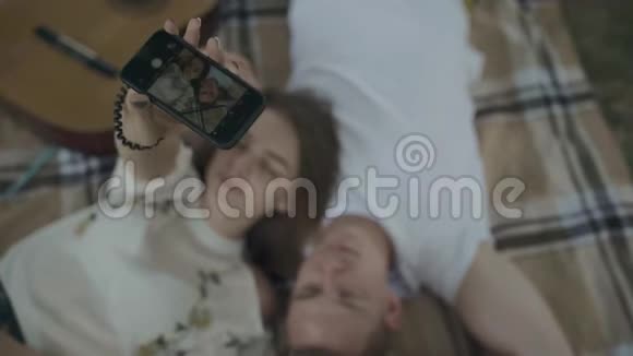 这对年轻夫妇正在毯子上自拍视频的预览图